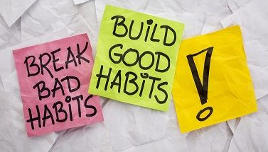 three post-it notes on wall one saying 'break old habits' the other saying 'build good habits'